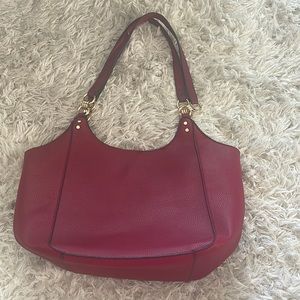 Crimson red purse with gold hardware zipper inside